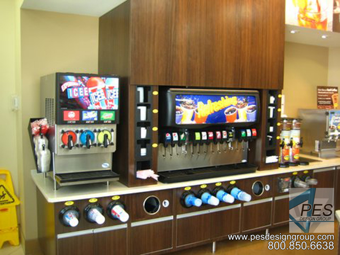 An attractive fountain beverage center with multi-flavor soda dispensers, frozen drink machines and built-in cup, lid and straw organizers.